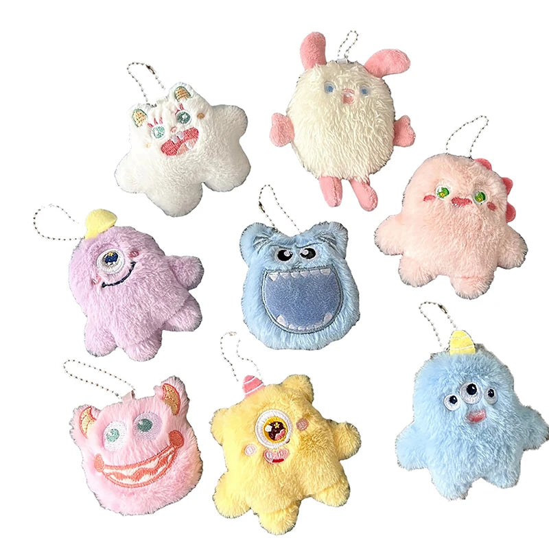 A collection of colorful fuzzy plush monster keychains in various pastel colors and shapes.