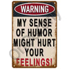 A vintage metal sign with a warning that says My sense of humor might hurt your feelings