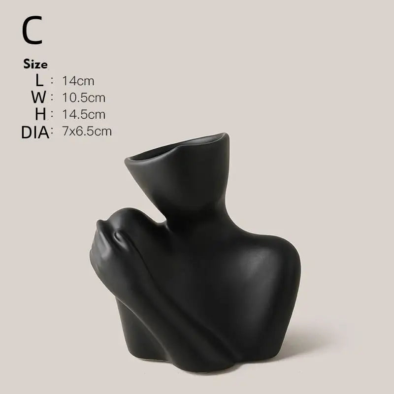 A black ceramic figural vase shaped like an artistic human form.
