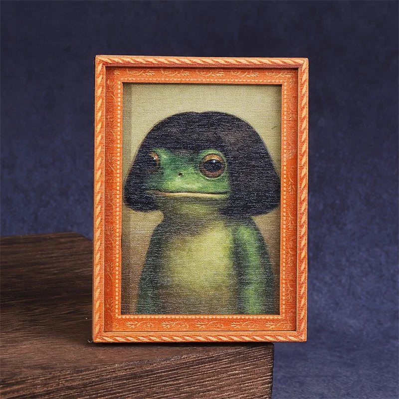 A framed painting of a green frog in a wooden frame.
