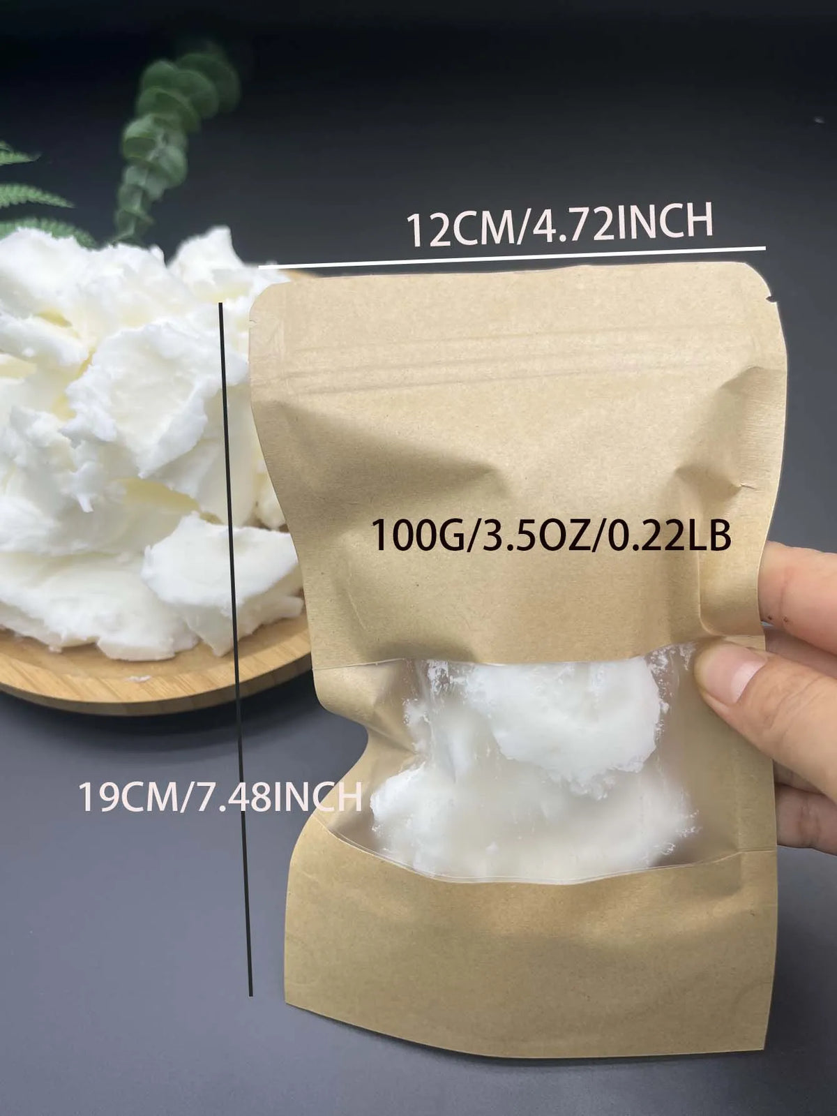 A hand holds a brown paper pouch containing 100g of white natural coconut wax for candle making.