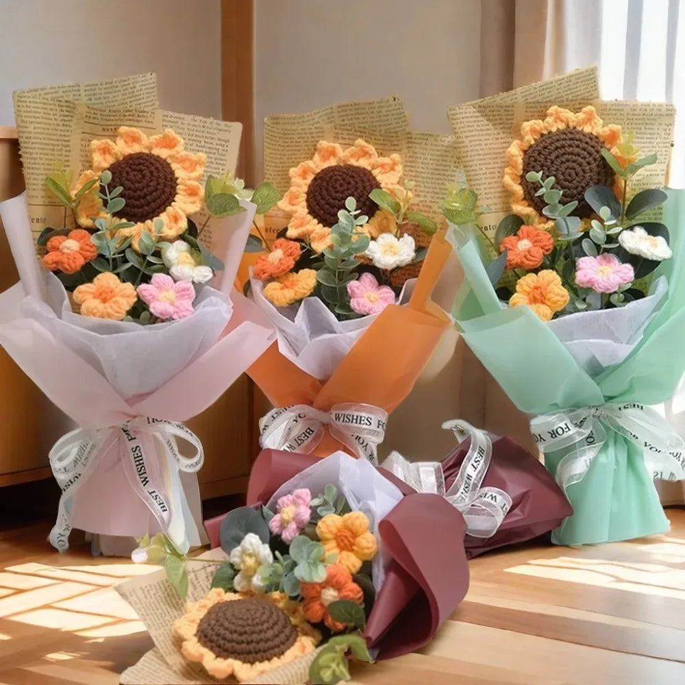 A bouquet of handcrafted crochet sunflowers and daisies in various shades of orange, yellow, and pink flowers wrapped in ligh