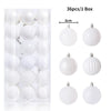 A box containing 36 white spherical Christmas tree ornaments with silver hanging loops.