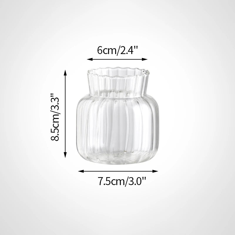 A clear glass vase with a fluted rim and rounded body, shown with dimensions 6cm/2.4" wide and 8.5cm/3.3" high.