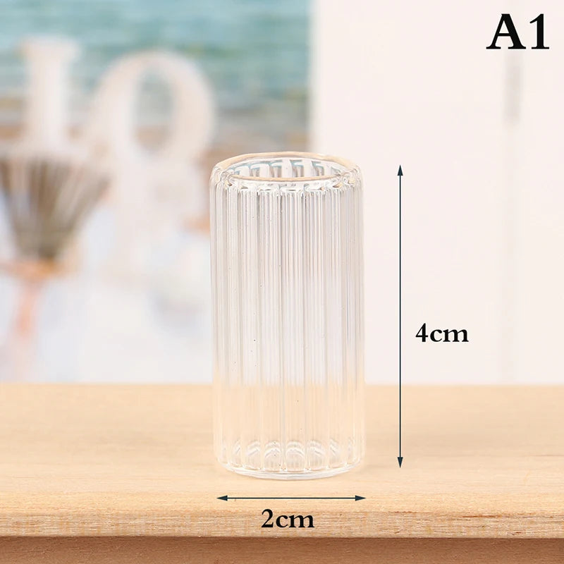 A clear glass cylindrical vase or bottle with vertical ridges, shown on a wooden surface.