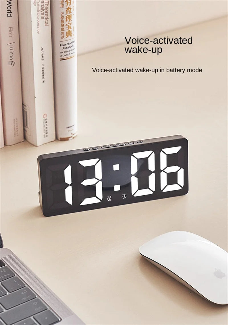 A black LED digital alarm clock displaying 13:06 is shown on a light surface next to a laptop and a white mouse.