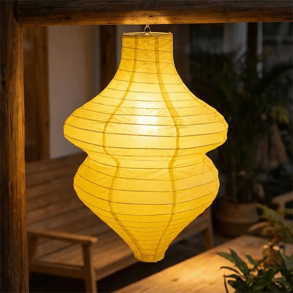 A glowing yellow handmade vintage flower bottle lantern hanging in a wooden frame.