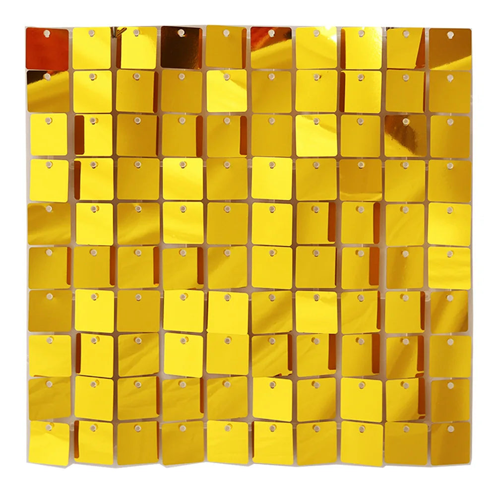 A grid of square, reflective gold and copper glitter panels used as a wall backdrop.