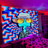 Vibrant tapestry wall art featuring a psychedelic blue and purple character design illuminated by neon lights.