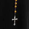 A rosary necklace featuring gold beads and a silver cross pendant.