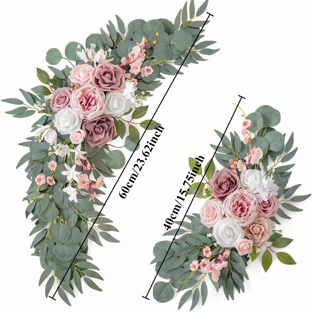 A floral arrangement featuring dusty rose and white roses with pink accents and eucalyptus greenery.