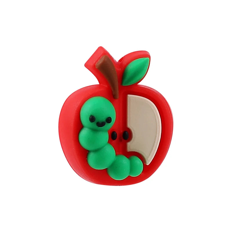 A bright red silicone apple with a green stem and leaves, used as a plant bead for crafts.