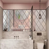 A modern bathroom featuring a vanity with a sink and mirror framed by diamond-patterned glass panels.