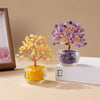 A natural crystal money tree ornament featuring yellow and purple crystals displayed in glass jars.