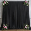 A dark gray satin backdrop curtain with vertical pleats and floral greenery on the sides.