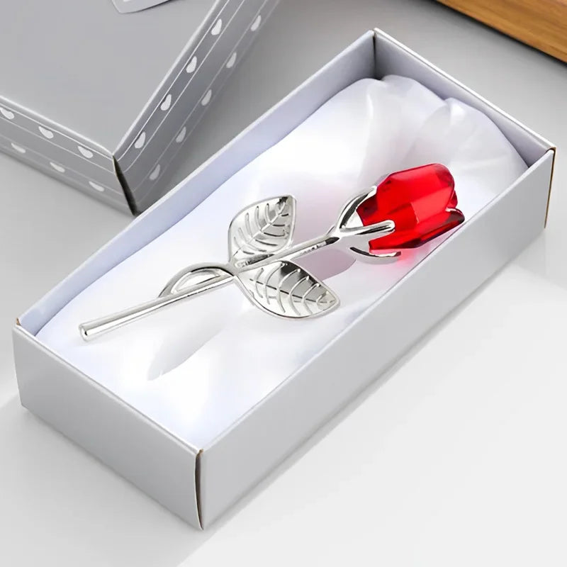 Silberner Löffel mit roter Glasrosenverzierung in einer weißen Geschenkbox.