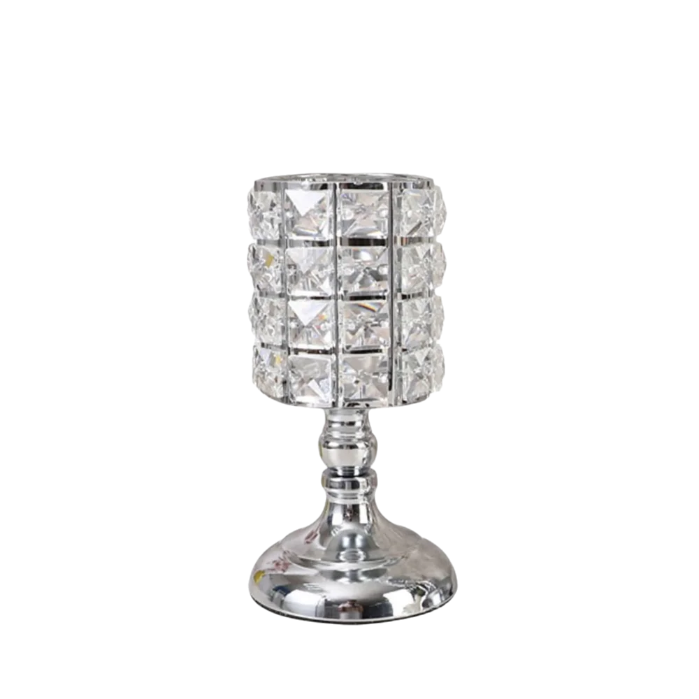 Portavelas de cristal transparente con cuenco facetado y base decorativa.