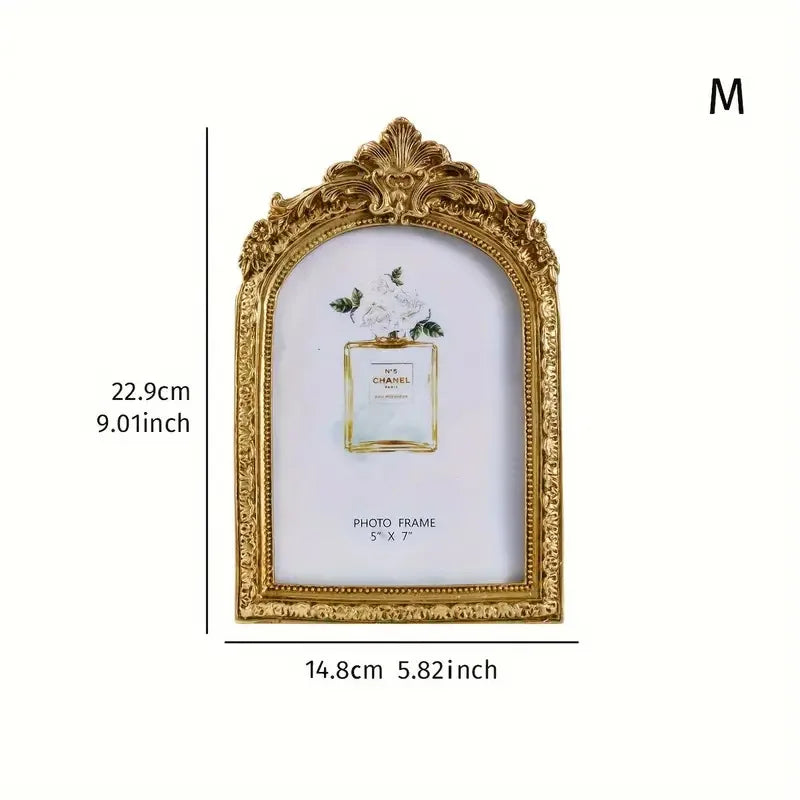 Gold-framed vintage resin photo frame with a white background and floral accent