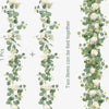 Two artificial eucalyptus garlands with white roses tied together for decor