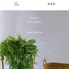 A long green artificial ivy vine garland draped over a wooden plant stand.