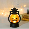 A black hanging lantern with an orange glowing pumpkin inside, used for Halloween decoration.
