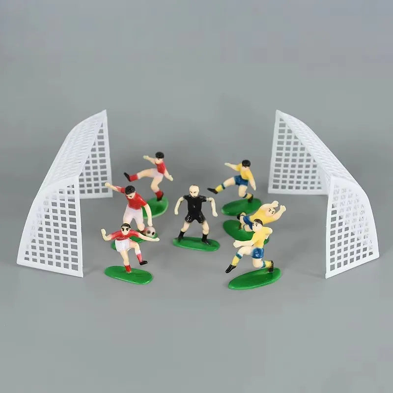 Football birthday cake toppers featuring soccer players and field decor set against a gray background.