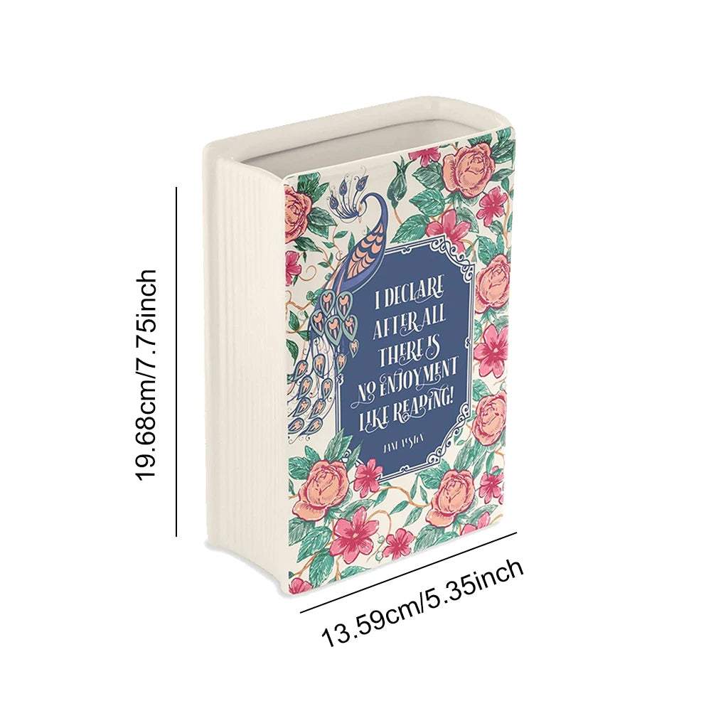 A ceramic book-shaped vase with a vintage floral design in pale green and pink tones.