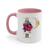 A pink ceramic coffee mug featuring a gold letter P decorated with floral elements.