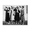 Black and white photograph of four women in period dress drinking from bottles against a wooden wall.