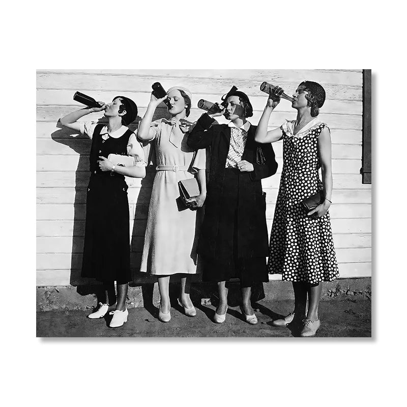 Black and white photograph of four women in period dress drinking from bottles against a wooden wall.