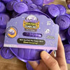 A hand holds a purple Halloween themed sticky fidget dumpling product packaging with a question mark and ghost design.