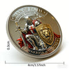 A silver coin featuring a 3D carved lion warrior design with text surrounding the image.