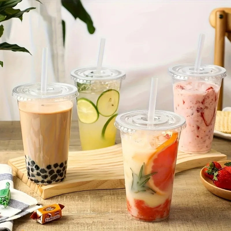 A collection of colorful iced beverages in clear plastic cups with lids, including tea, lime juice, and fruit drinks.