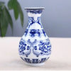 Blue and white ceramic flower vase with intricate floral patterns on a light background.