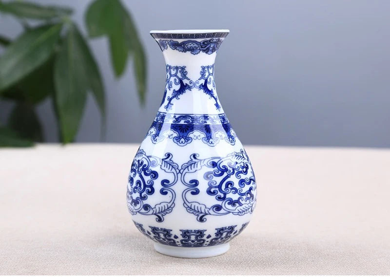 Blue and white ceramic flower vase with intricate floral patterns on a light background.