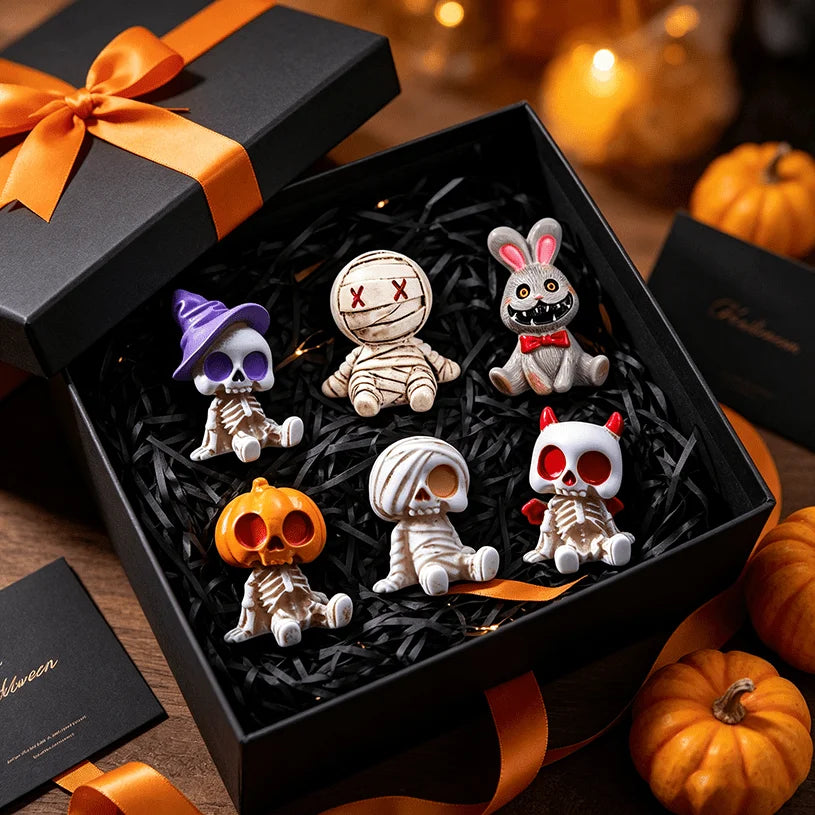 A black box containing a set of Halloween resin skeleton mummy figurine decorations on a dark background.