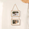 A set of two rustic wooden collage photo frames hanging on a wall with natural twine.