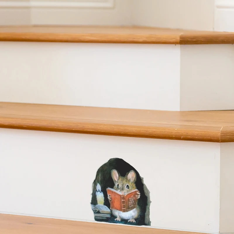 A cartoon mouse is depicted reading a book on a white wall, used as a removable decor sticker.