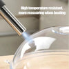 A close-up of a transparent microwave splatter guard with a metal handle and steam vent being used.