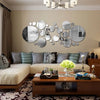 A modern living room featuring a beige wall with a decorative arrangement of round acrylic mirrors.