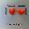 Two red heart-shaped fridge magnets displayed next to a measurement scale.