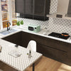 A modern kitchen featuring dark cabinetry, a speckled countertop, and a backsplash with a diamond pattern.