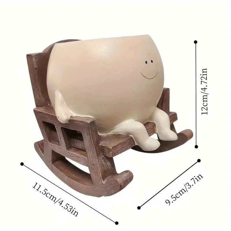A beige resin ornament shaped like a smiling face, displayed on a wooden stand.