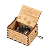 A vintage hand-cranked wooden music box with a lid engraved 'Merry Christmas' and a silver crank mechanism.