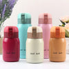 Four pink and peach colored vacuum insulated coffee mugs with lids displayed on a white surface.