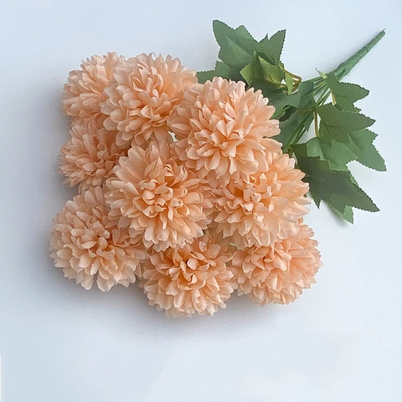 A bouquet of artificial peach-colored hydrangea and green camellia flowers.