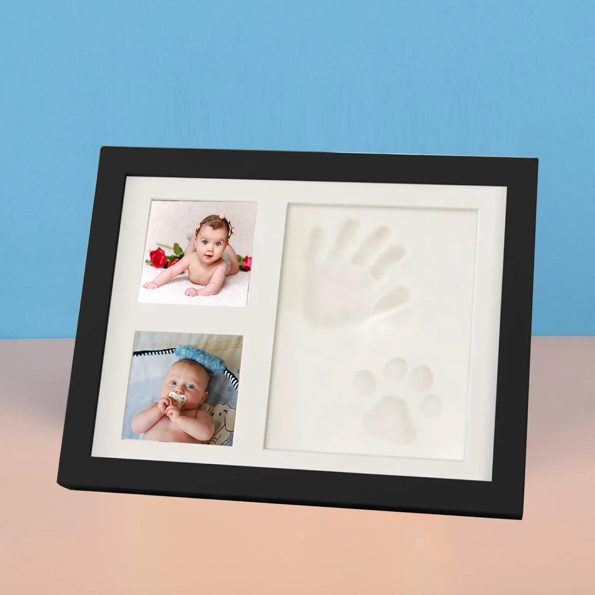 A black photo frame displaying two baby handprints and footprints on white backgrounds.