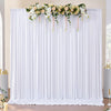 White sheer polyester backdrop curtains decorated with a floral garland for an event or photo shoot.