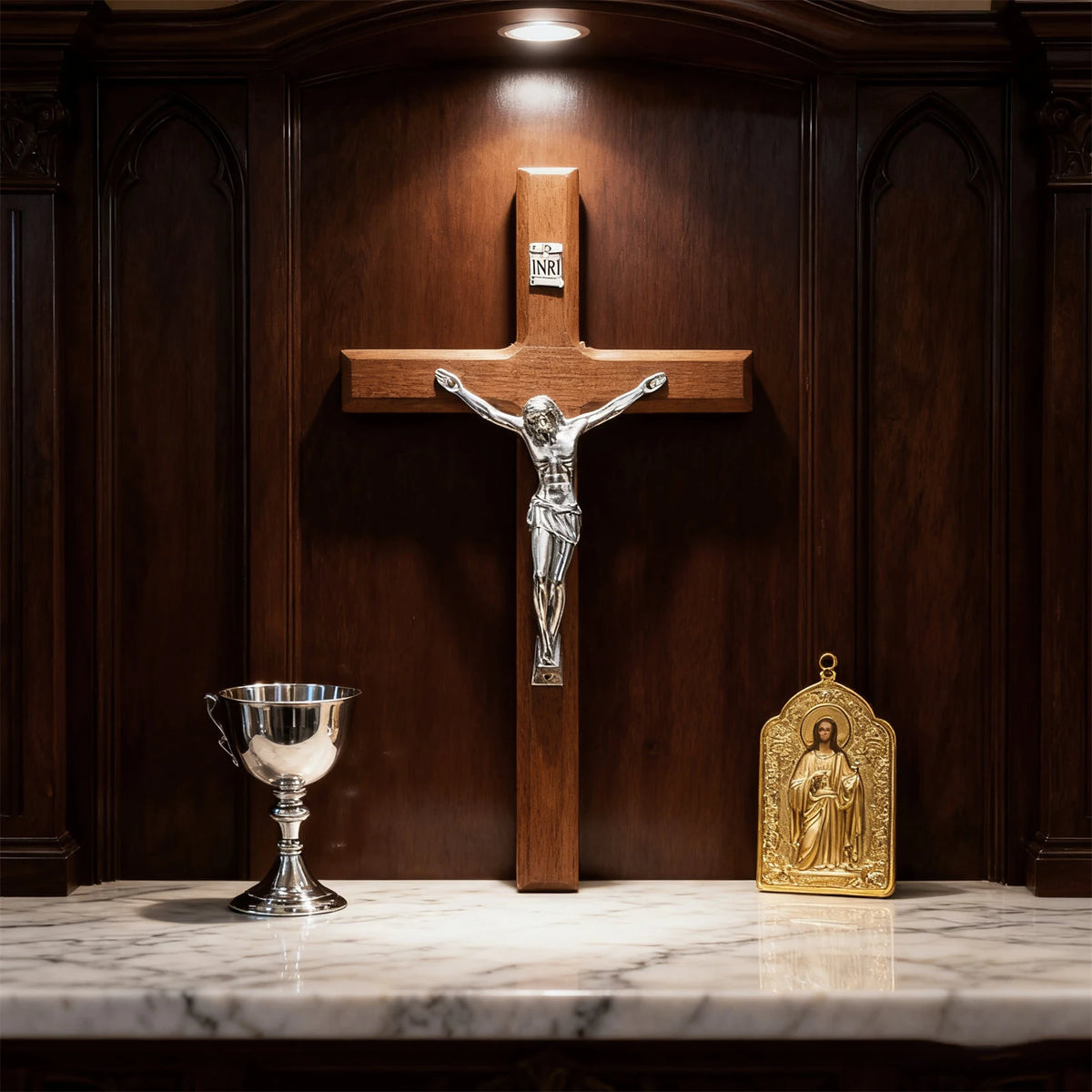 A handcrafted wooden cross wall decor mounted on a dark wood panel, next to a silver chalice and a gold religious figure.
