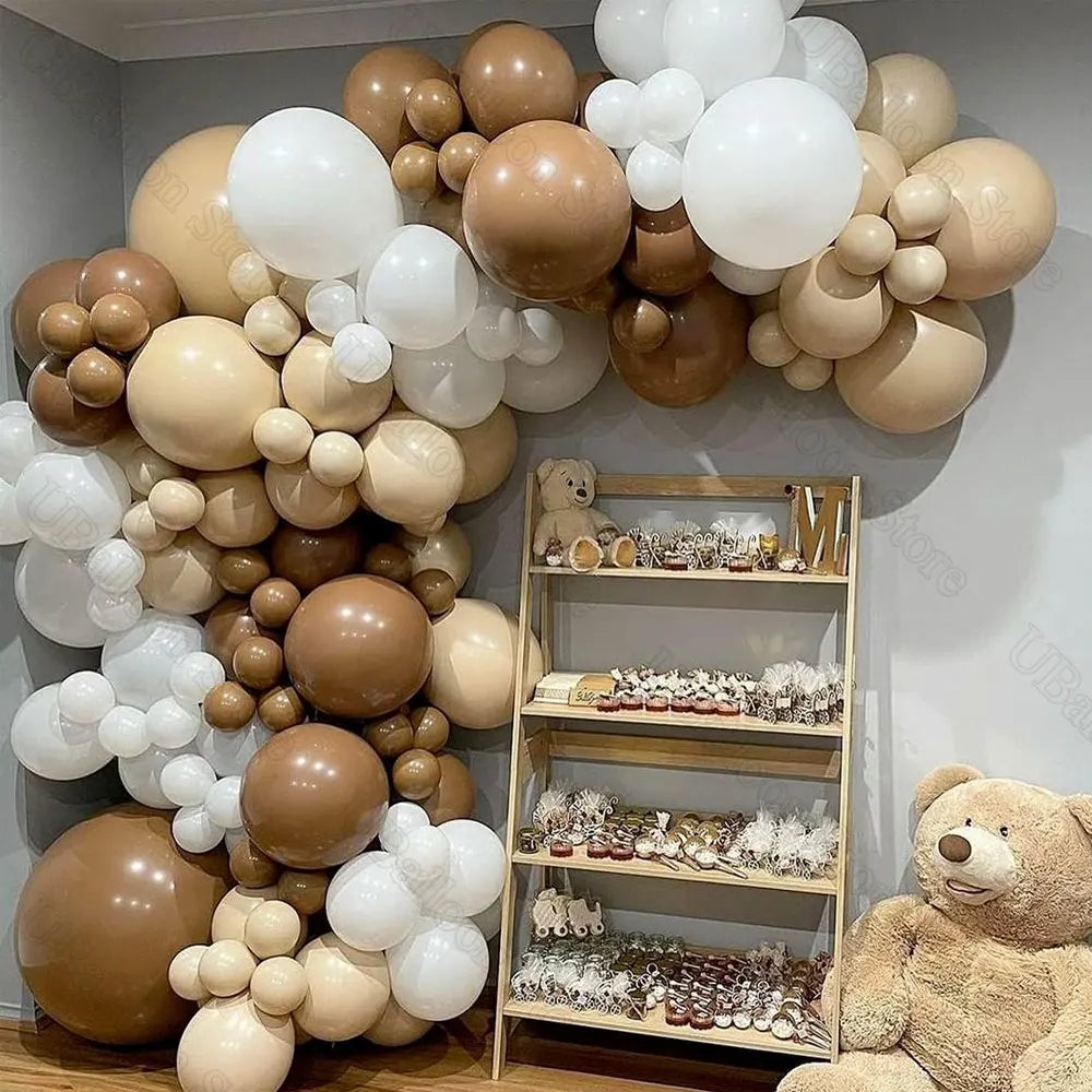 A large arrangement of brown and white latex balloons in neutral shades for baby shower or birthday décor